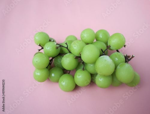 Anggur hijau. Bunch of Green Seedless Grape solated on pink background. Clipping path. photo