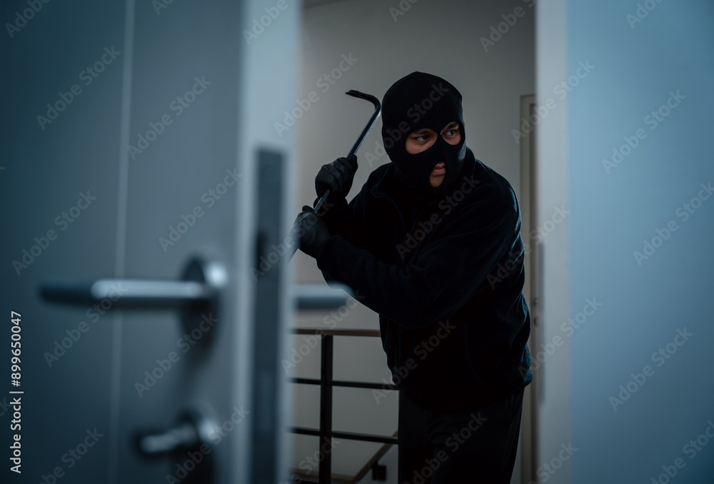 Thief in uniform black jacket various action housebreak. The Robber terrorism criminal escapes with balaclava and crowbar entering a house for stealing Housebreak at night Thief in uniform black jacket various action housebreak. The Robber terrorism criminal escapes with balaclava and crowbar entering a house for stealing Housebreak at night