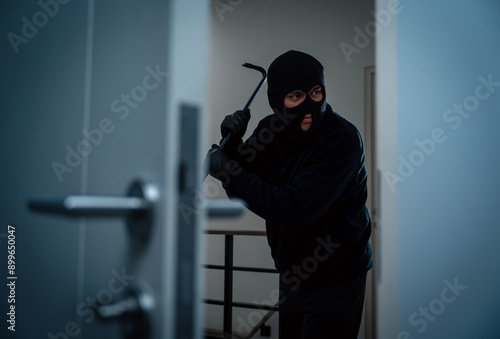 Thief in uniform black jacket various action housebreak. The Robber terrorism criminal escapes with balaclava and crowbar entering a house for stealing Housebreak at night