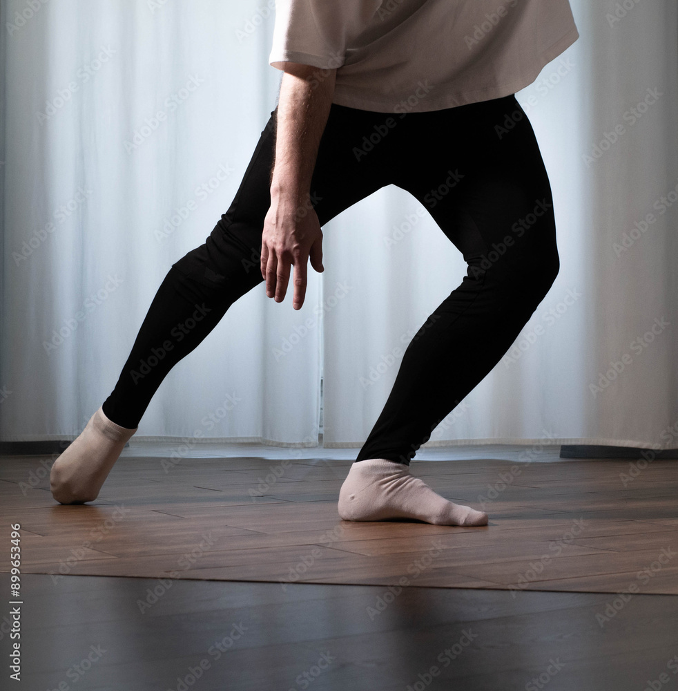 Ballet dance pose Dance poses in the studio. Male dancer warms up during training. Ballet dance pose Dance poses in the studio. Male dancer warms up during training.