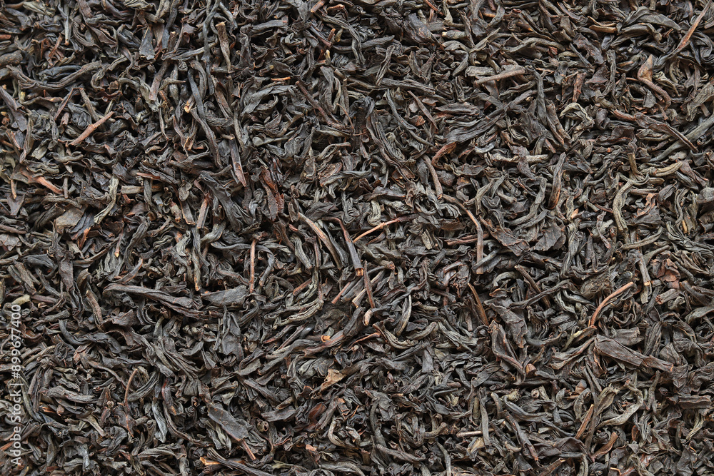 Long black tea, texture. Top view of dried tea leaves. Tea composition. Ingredients for a hot drink, close-up. Background Long black tea, texture. Top view of dried tea leaves. Tea composition. Ingredients for a hot drink, close-up. Background