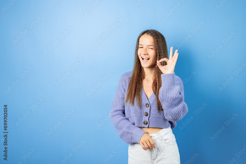 Teenager shows ok sign with hands, happy adolescent with curly hair, positive emotion and joy. Teenager shows ok sign with hands, happy adolescent with curly hair, positive emotion and joy.