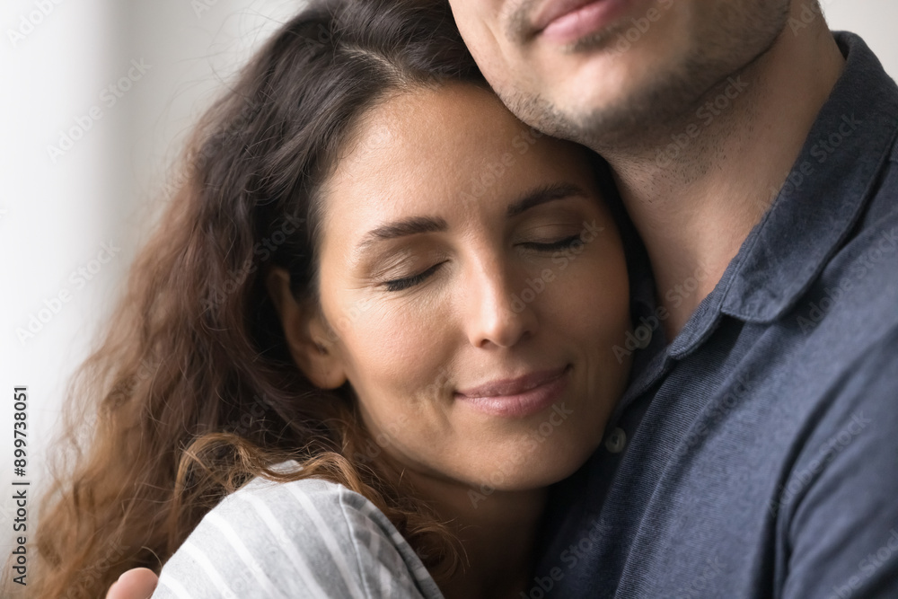 Close up face view of serene beautiful Hispanic woman enjoy moment of love, warmth, caress, cuddling husband with eyes closed. Pure love, happy strong marriage, trust and support between young spouses Close up face view of serene beautiful Hispanic woman enjoy moment of love, warmth, caress, cuddling husband with eyes closed. Pure love, happy strong marriage, trust and support between young spouses