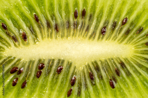 Ripe kiwi with green flesh cut lengthwise with details of the white center and seeds photo