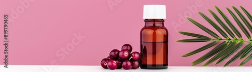 Close-up of acai berry pills in a glass bottle on a pink background. photo