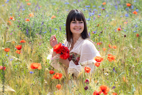 young medieval girl happy on a flower meadow