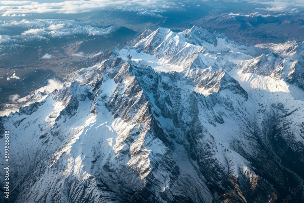 Fototapeta premium This photo captures an expansive aerial view of a snow-covered mountain range, showcasing the majestic peaks and valleys below, Majestic peaks of the Swiss Alps from a top-down view, AI Generated