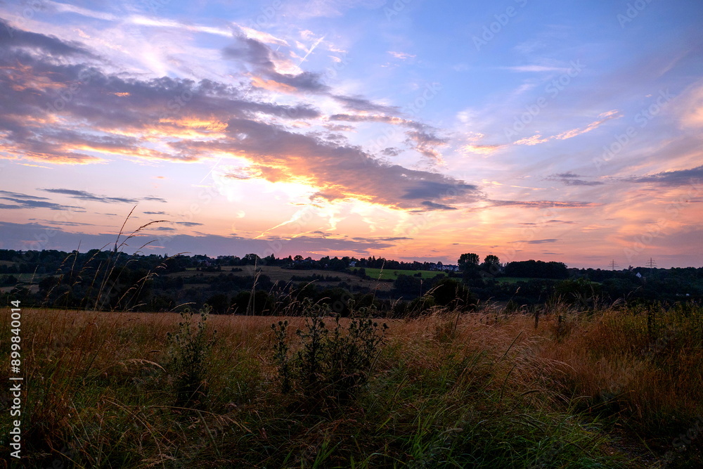 Abenddämmerung über blühenden Feldern zwischen Berg und Tal Abenddämmerung über blühenden Feldern zwischen Berg und Tal