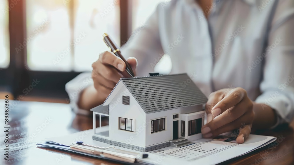 Fototapeta premium Real estate agent home sales broker is using a pen pointing to the house model and explains the business contract, rent, buy, mortgage, loan, or home insurance AI generated