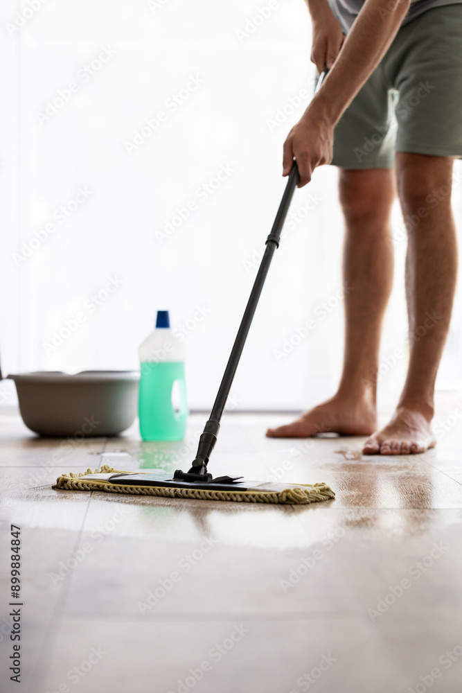 man washing floor with cleaning agent, cleaning agent bottle and mop , floor cleaning and homework concept man washing floor with cleaning agent, cleaning agent bottle and mop , floor cleaning and homework concept