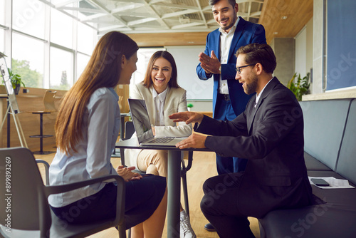 Business people diverse group, high performance team office interaction, organization. Colleague gathering at desk with laptop for effective talk, strategic assessments, practical workshops, coaching photo