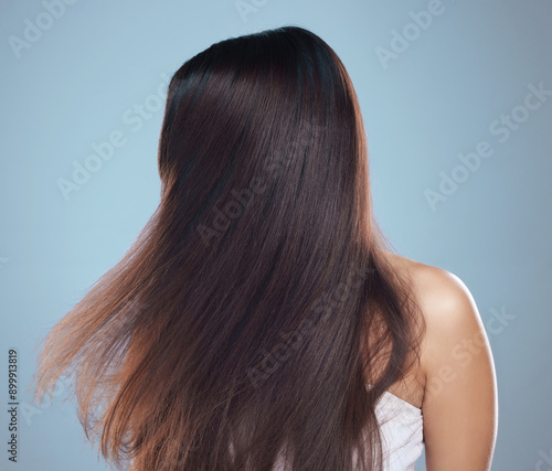 Woman, shine and shaking hair in studio for keratin treatment, shampoo and beauty salon aesthetic. Female person, wind and healthy hairstyle with glow, strong textures and growth by blue background