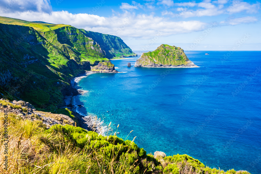 Fototapeta premium Beautiful bay with beach on ocean coast with green cliffs at Baia de Alem, Flores island, Azores, Portugal