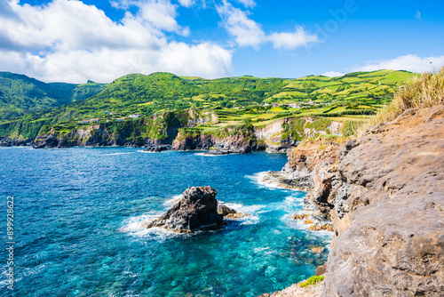 Beautiful bay with rocks on ocean coast with green cliffs at Ponta Delgada, Flores island, Azores, Portugal