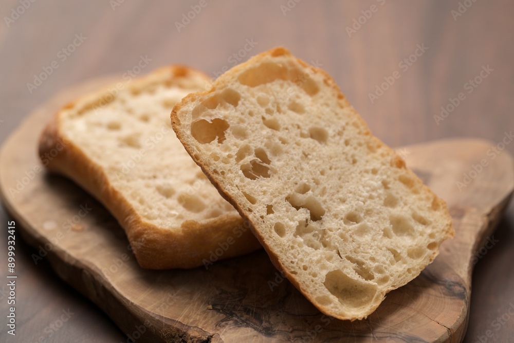 sliced ciabatta bun on wood board closeup sliced ciabatta bun on wood board closeup