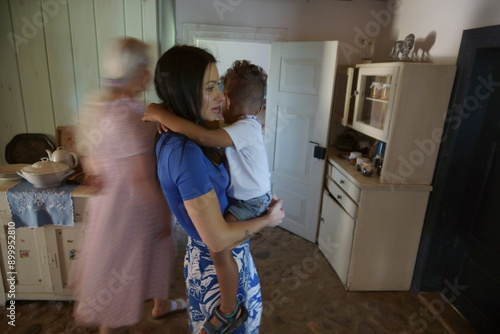 Obraz na płótnie Rodzina w kuchni. Mama trzymająca dziecko na rękach. w salonie
