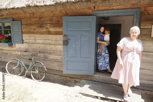 Obraz na płótnie Rodzina przed domem. Mama dziecko i babcia. w salonie