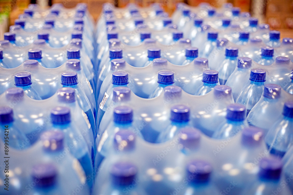 drinking water packaged in plastic containers on the shelves in the supermarket drinking water packaged in plastic containers on the shelves in the supermarket