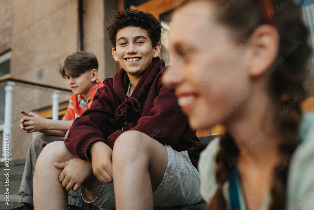 Portrait of smiling boy sitting with friends on staircase of school building entrance Portrait of smiling boy sitting with friends on staircase of school building entrance