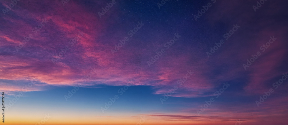 Fototapeta premium Himmel bei Sonnenuntergang mit intensiven Rosa- und Violetttönen, die den klaren Himmel und die Wolken in eine traumhafte und beruhigende Atmosphäre tauchen