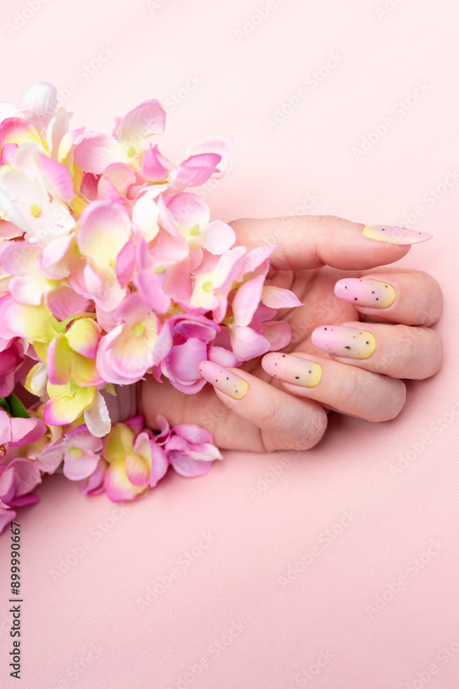 women's hands with painted nails and flowers on their hands. delicate manicure women's hands with painted nails and flowers on their hands. delicate manicure