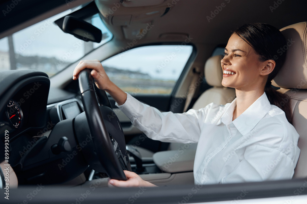 A joyful woman sits in the driver's seat, hand on the steering wheel, smiling confidently while looking straight ahead A joyful woman sits in the driver's seat, hand on the steering wheel, smiling confidently while looking straight ahead