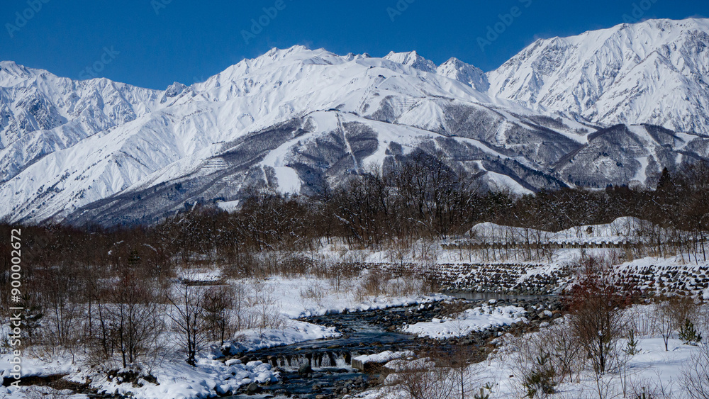 Fototapeta premium 冬の北アルプスと雪が残る河川 長野県白馬村