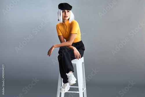 Fotografía Woman, stool and fashion in studio with hat for confidence, thinking and style inspiration ideas