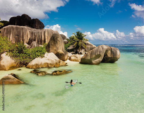 Young woman kayaking during summer day at La Digue island.