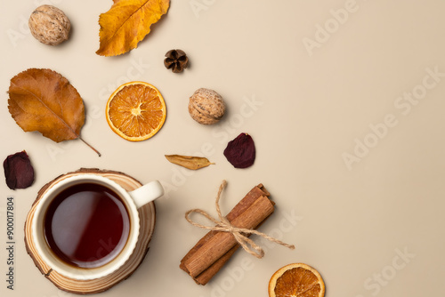 Wallpaper Mural Autumn composition with cup of tea, leaves, nut, cones, dried fruits, cinnamon sticks on beige background. Top view, flat lay Torontodigital.ca