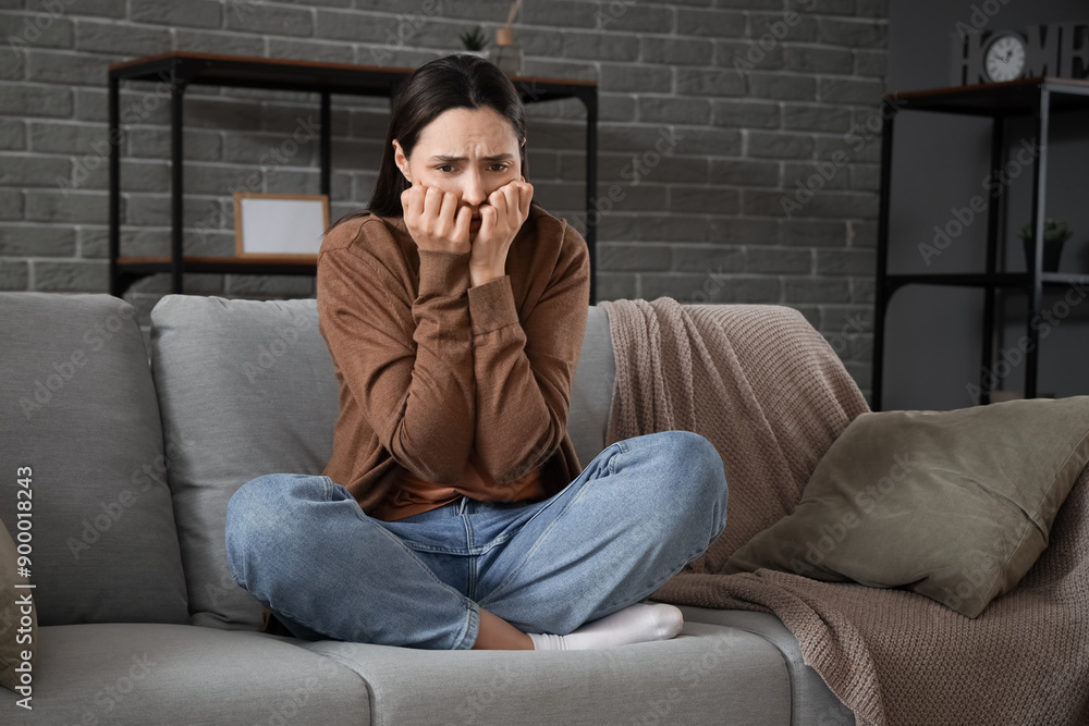 Depressed young woman crying on sofa at home Depressed young woman crying on sofa at home