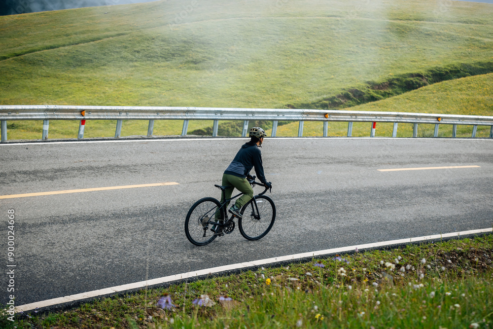 Fototapeta premium Riding bike on grassland mountain top trail