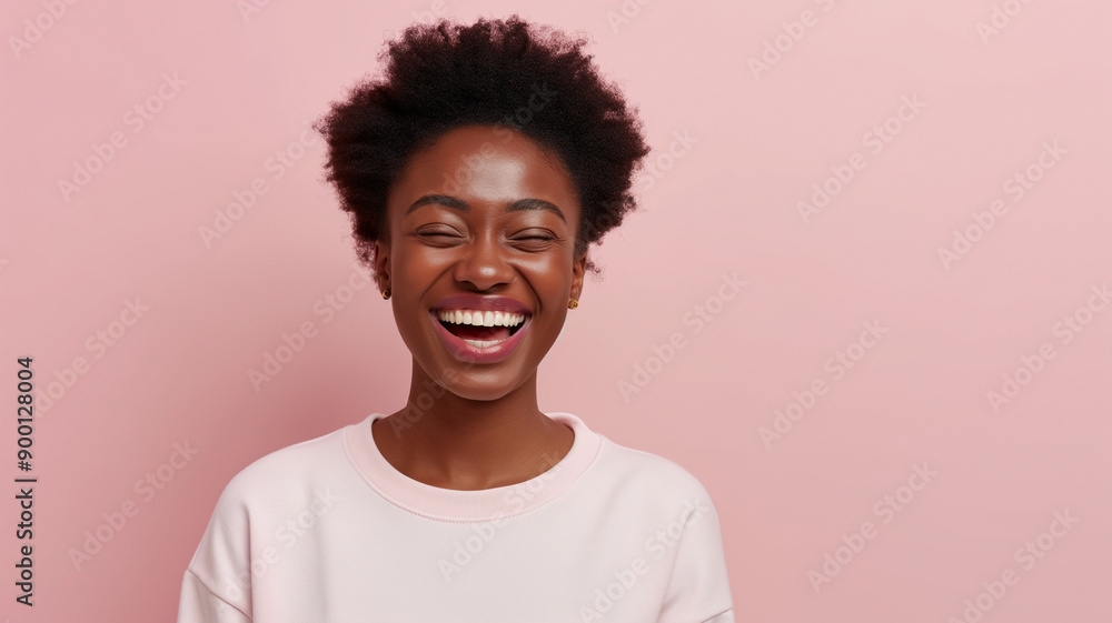 A young woman with natural afro hair and brown eyes laughing joyfully. She is wearing a pink sweater and stands against a pink background, exuding a cheerful and vibrant atmosphere. A young woman with natural afro hair and brown eyes laughing joyfully. She is wearing a pink sweater and stands against a pink background, exuding a cheerful and vibrant atmosphere.