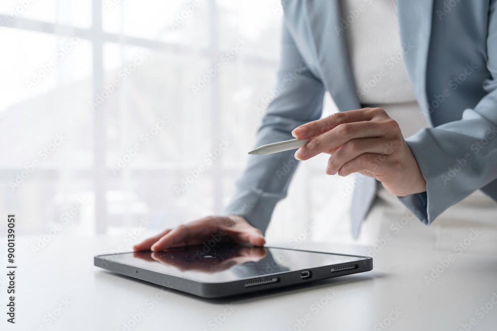 Businesswoman is using a digital tablet and stylus in a modern office, working on a project Businesswoman is using a digital tablet and stylus in a modern office, working on a project