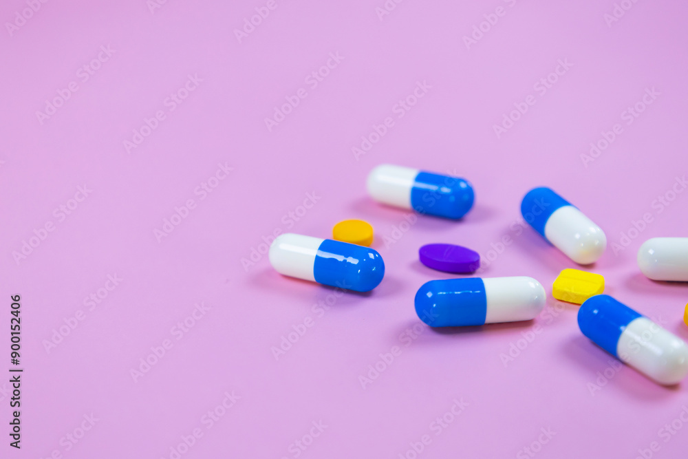 Multi-colored pills, capsules used in medical treatment are arranged in a gene pattern on a pink background. Healthcare and medical concept. concept of genetic illness. Space for text. Multi-colored pills, capsules used in medical treatment are arranged in a gene pattern on a pink background. Healthcare and medical concept. concept of genetic illness. Space for text.