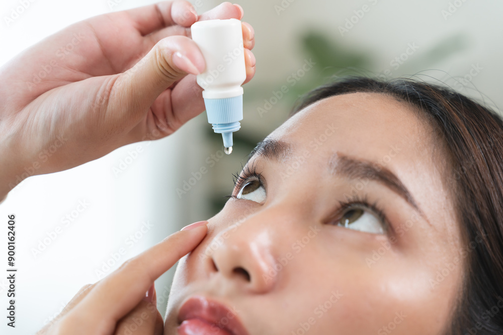 asian young woman using medical eye drops to treat dry eye and irritation. asian young woman using medical eye drops to treat dry eye and irritation.