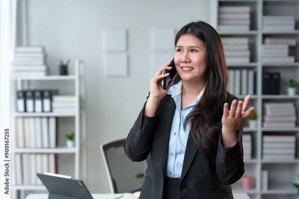 Asian businesswoman using a smartphone at her desk. Typing, chatting, texting, SMS, mobile applications, online shopping, talking. Contact online with co-workers Business customers in the office. Asian businesswoman using a smartphone at her desk. Typing, chatting, texting, SMS, mobile applications, online shopping, talking. Contact online with co-workers Business customers in the office.