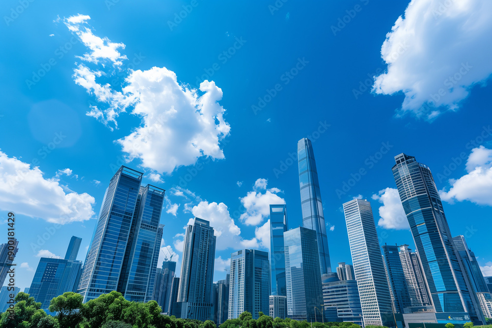 Fototapeta premium Skyscrapers Reaching into a Bright Blue Sky with White Clouds on a Sunny Day