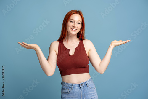 Fotografie Woman showing something on empty hands wearing casual clothes on blue background