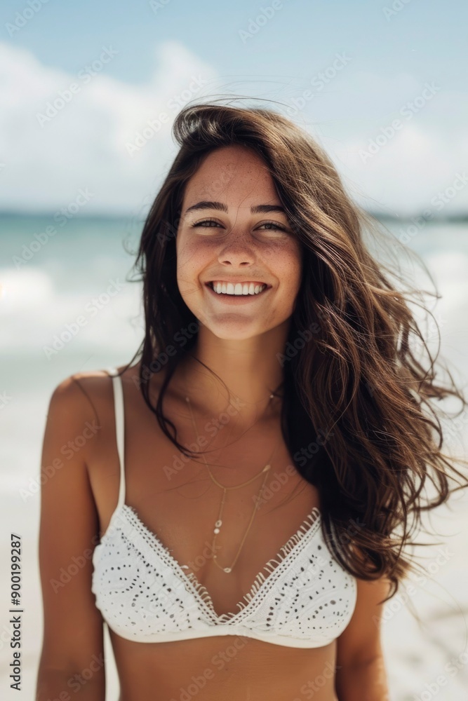 A woman in a white bikini top smiles at the camera on a beach A woman in a white bikini top smiles at the camera on a beach