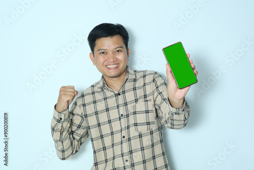 Young Asian man happy expression when showing green phone screen.Wearing a cream flannel shirt photo