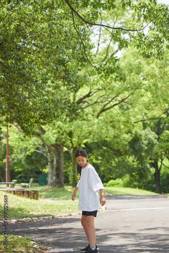 夏休みの公園で楽しくリップスティックで遊んでいる小学生の女の子の様子