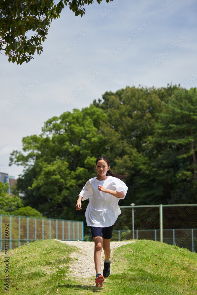 夏休みの公園で楽しく遊んでいる小学生の女の子の様子 夏休みの公園で楽しく遊んでいる小学生の女の子の様子