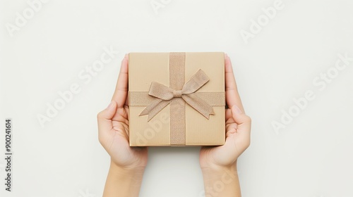 A beautifully wrapped gift held in hands, ready to be given photo