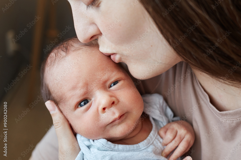Closeup portrait of unrecognizable mother kissing her newborn baby anonymous woman holding kid in hands after waking up Closeup portrait of unrecognizable mother kissing her newborn baby anonymous woman holding kid in hands after waking up