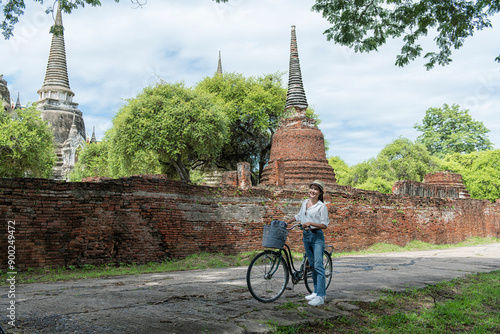 Woman travel in historical temple with bicycle. Tourist Travel taking a photo temple in Ayutthaya historical Park UNESCO world heritage site.	