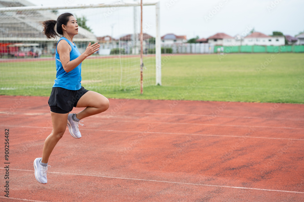 Asia mature woman runner training on racetrack and field Asia mature woman runner training on racetrack and field
