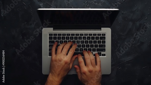 Hands typing on laptop on black background, top view. photo