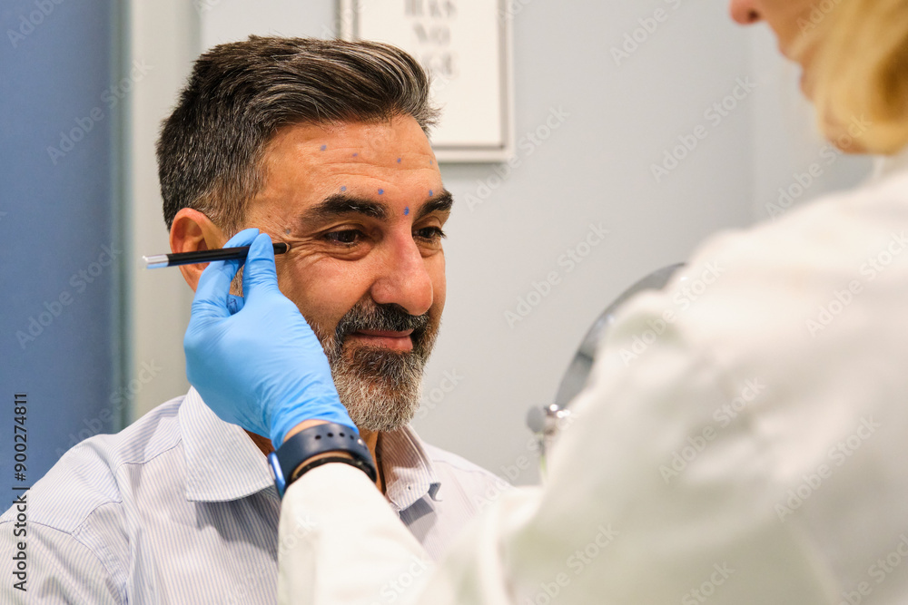 A man is getting ready to get Botox for crow's feet or laugh lines wrinkles by a aesthetic doctor in a clinic.