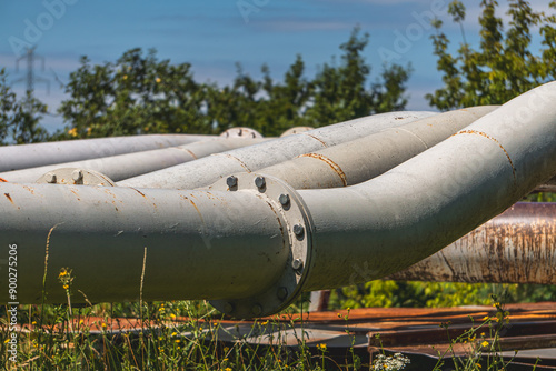 usty pipes, screws, rivets. industrial landscape against the background of blue sky and white clouds photo